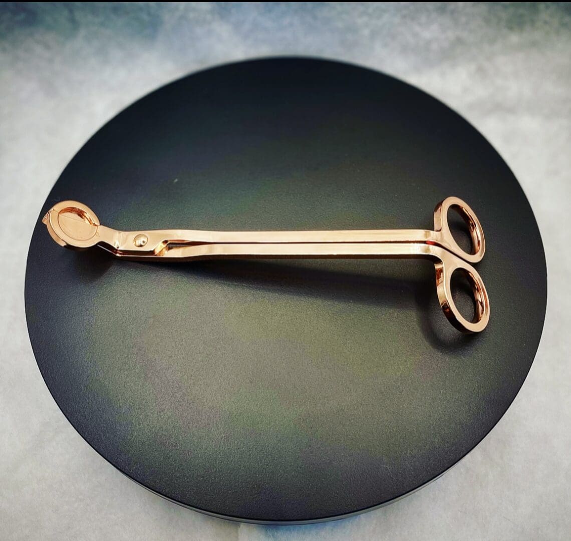 A pair of scissors sitting on top of a black plate.