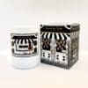An Ethereal candle in a white container beside its packaging box, both featuring black and white stylized designs and text.
