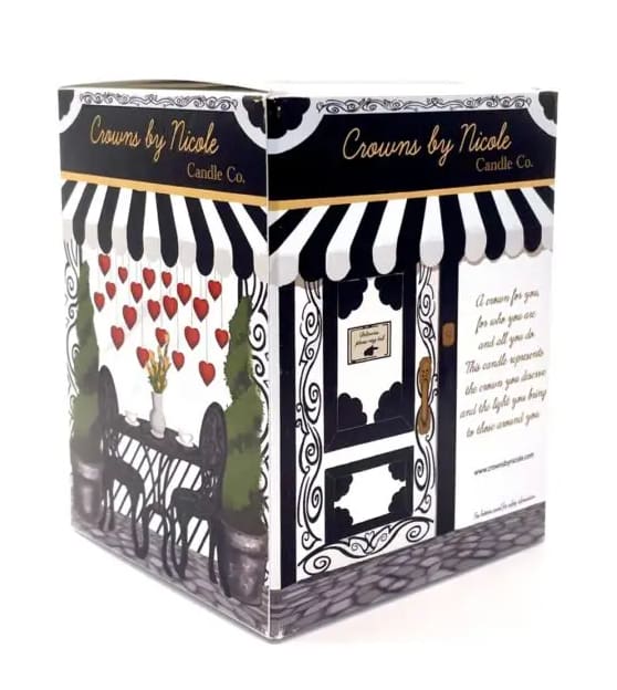 A decorative candle box designed to resemble a boutique shop, featuring a black and white striped awning and illustrations of chairs and flowers on the facade.