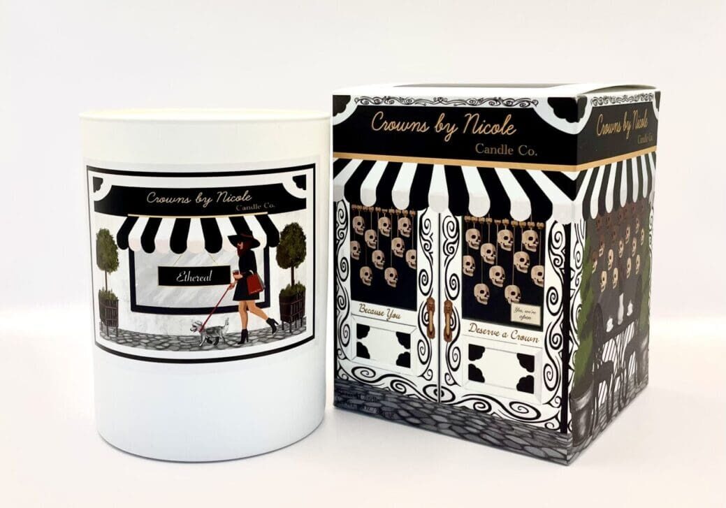 A Sass in Scarlett candle in a white container next to its patterned packaging box, both labeled "candles by Nicole.